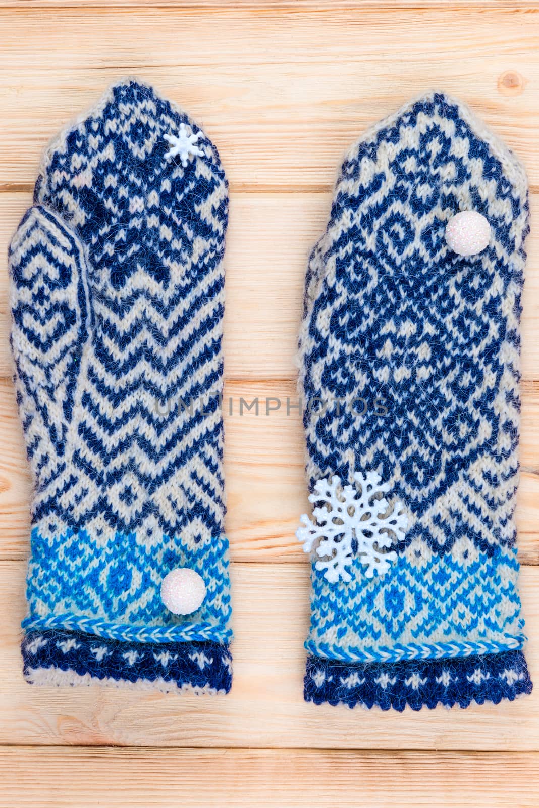 warm blue knitted mittens with winter pattern close up