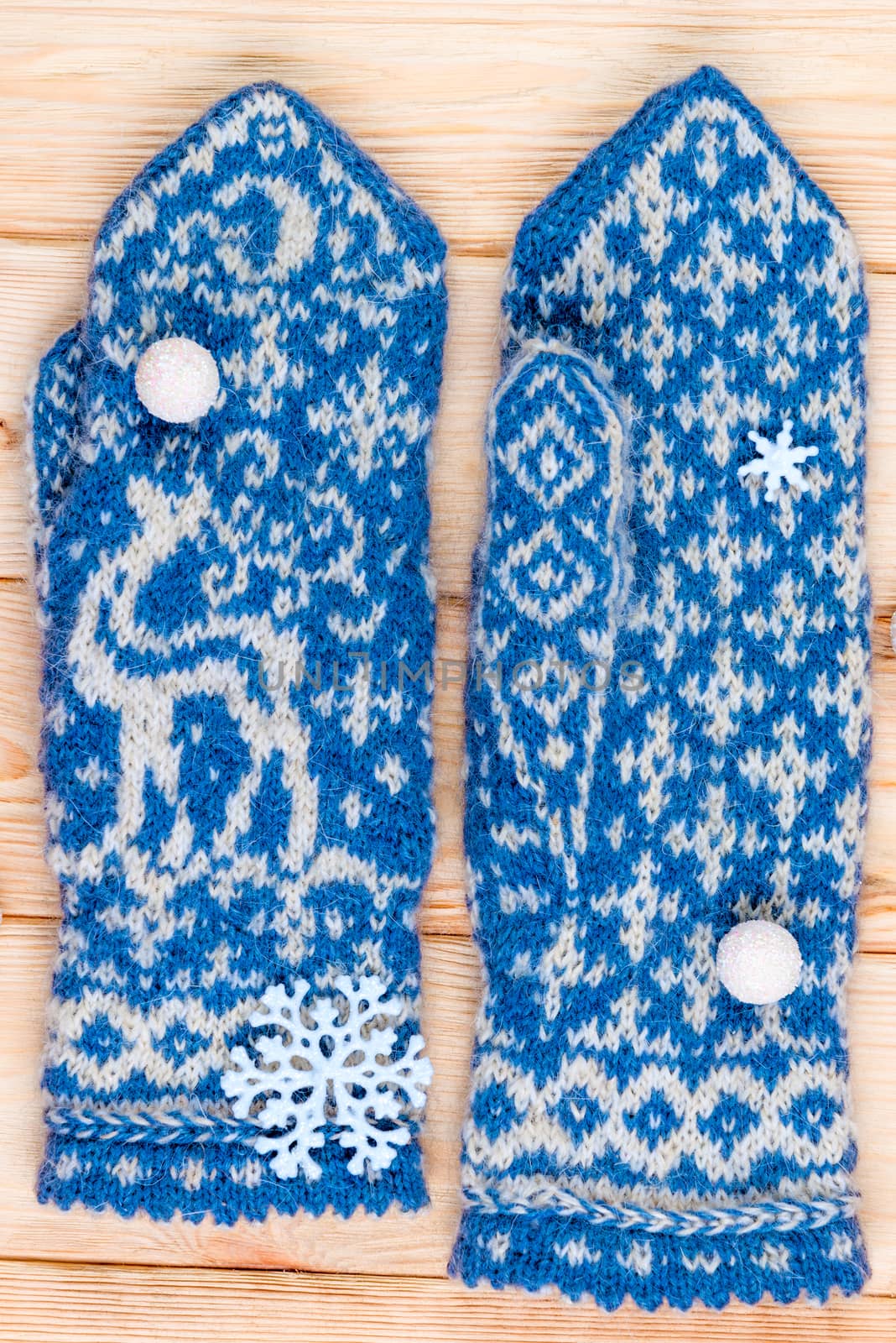 handmade blue mittens with a deer pattern are warm and soft close-ups