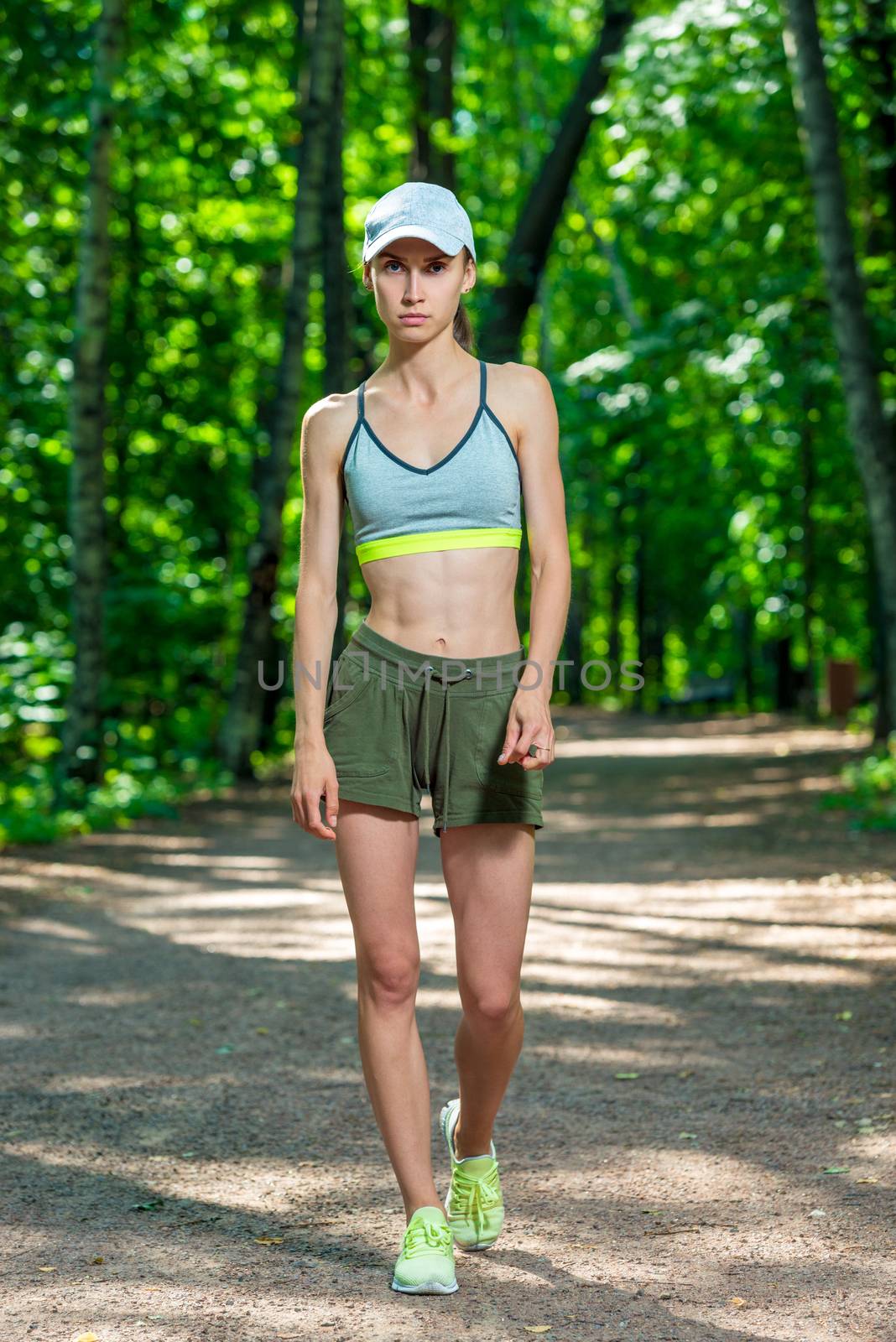 full length portrait of a female athlete in a summer park