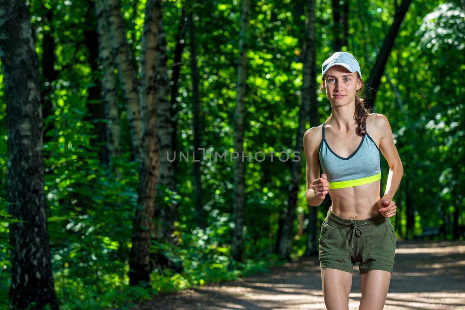 portrait of a female runner in a summer park by kosmsos111