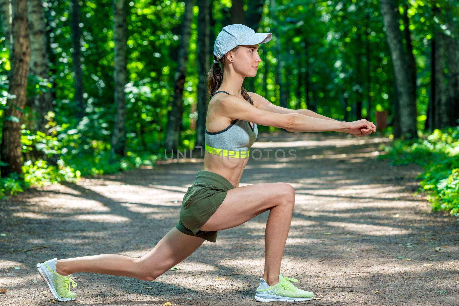 sporty woman performs stretching exercises in a summer park