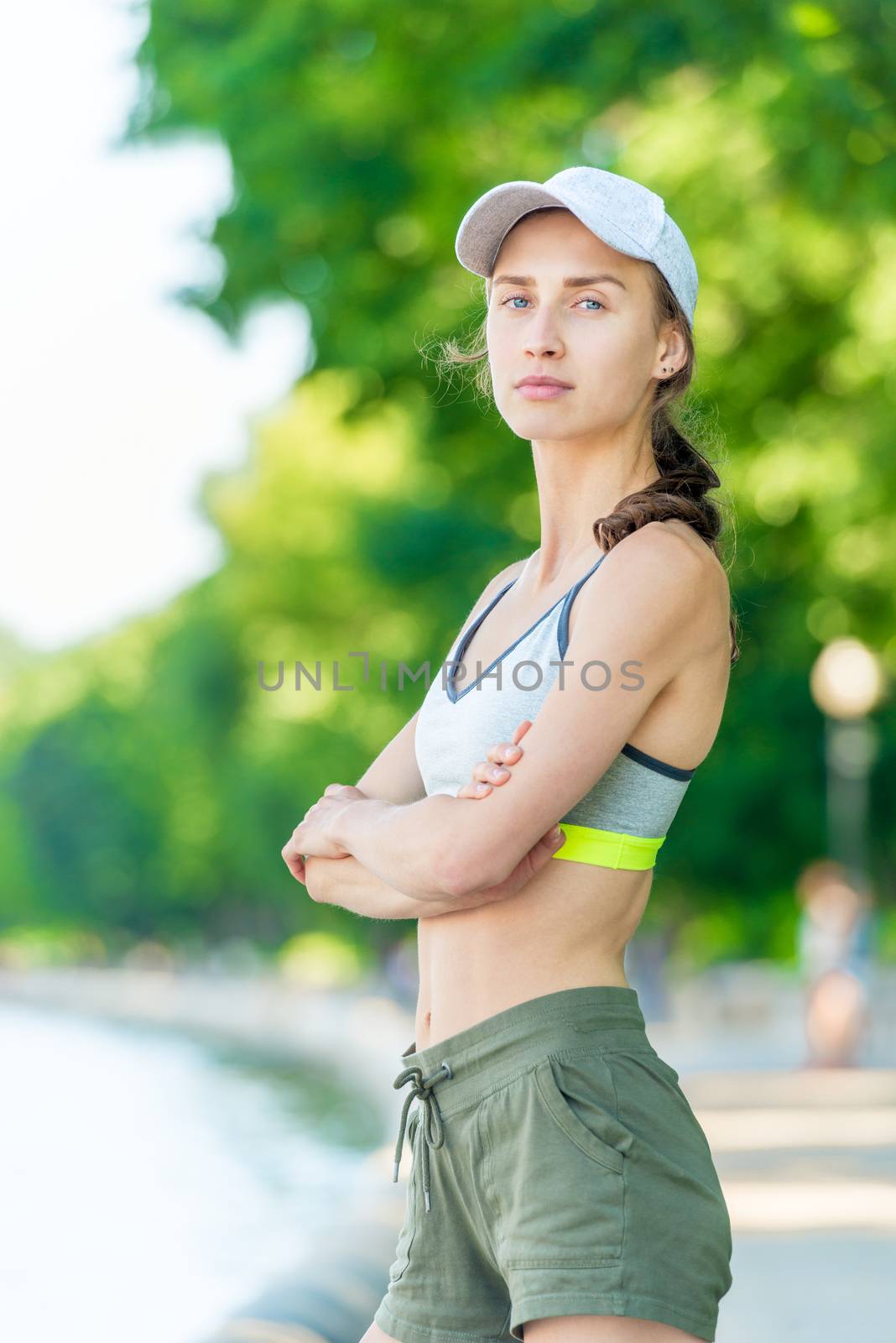 On the city embankment a vertical portrait of a close-up of a sporty girl who is posing