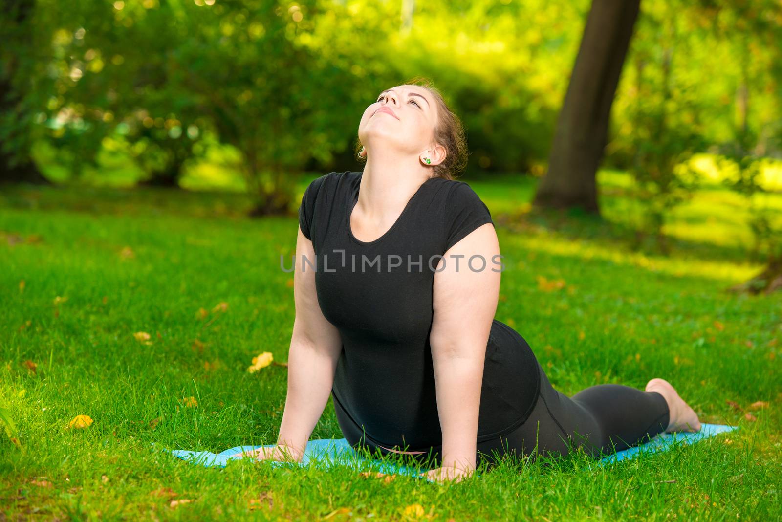 plus size sports woman in park performs stretching exercises, wo by kosmsos111