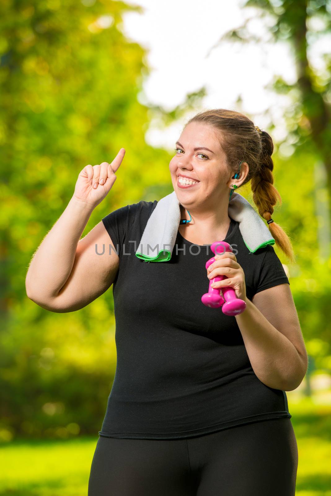 portrait happy woman 30 years old plus size without complexes deals with dumbbells during training