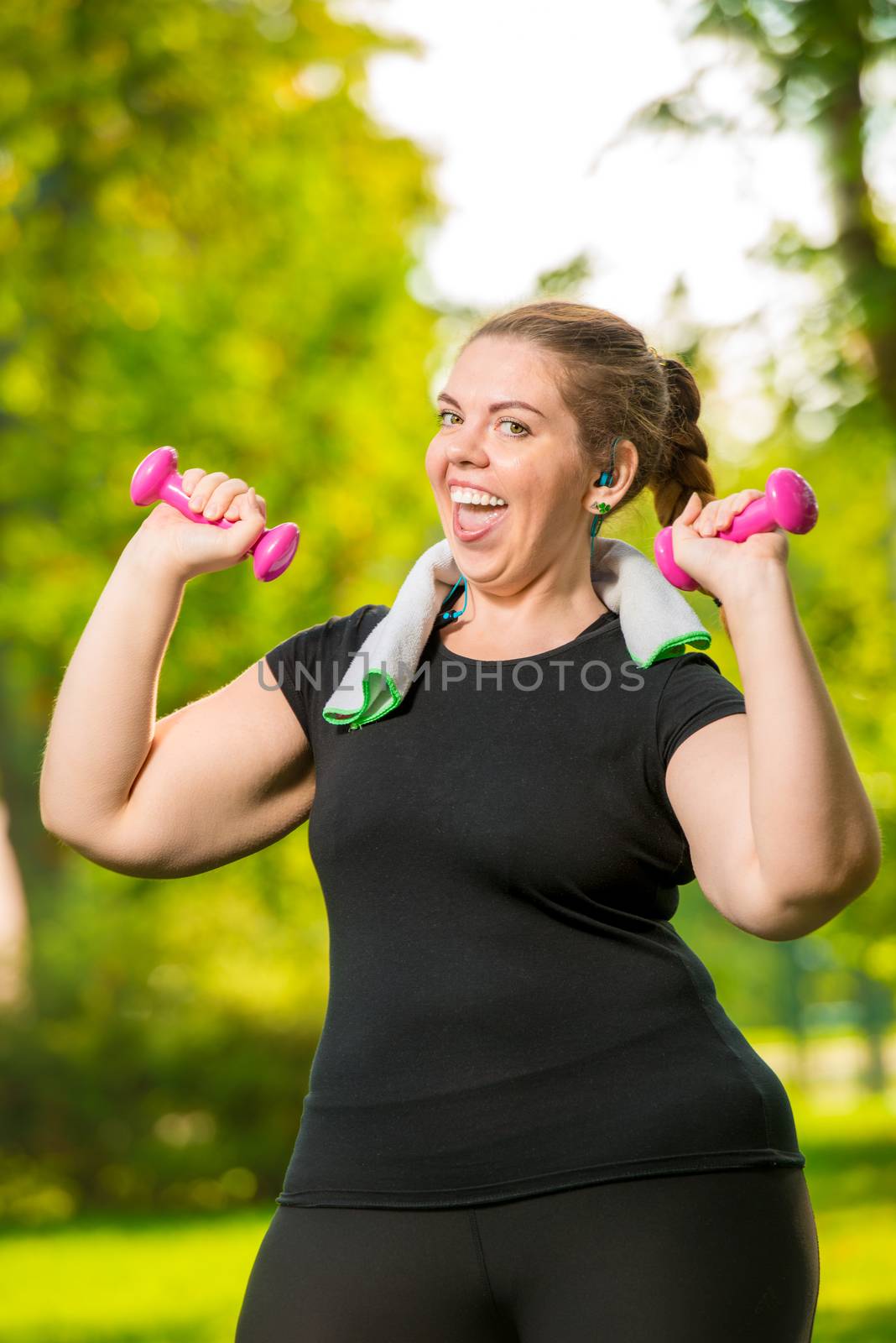 tending to harmony woman plus size without complexes deals with dumbbells in a summer park