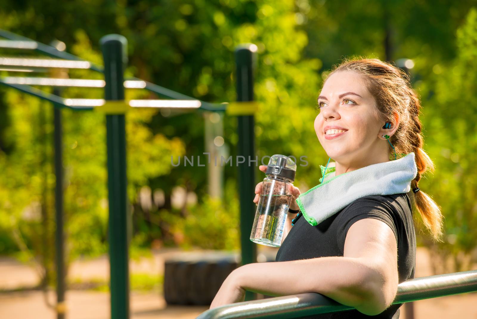 portrait of a large woman with a bottle of water next to the simulator in the park