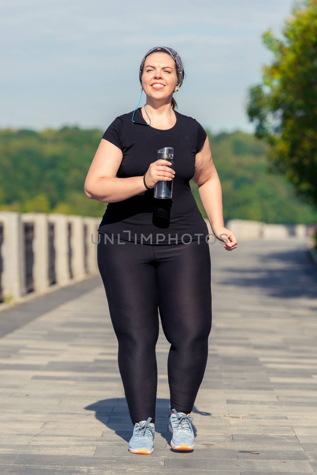 plus size active woman with a bottle of water during a morning j by kosmsos111