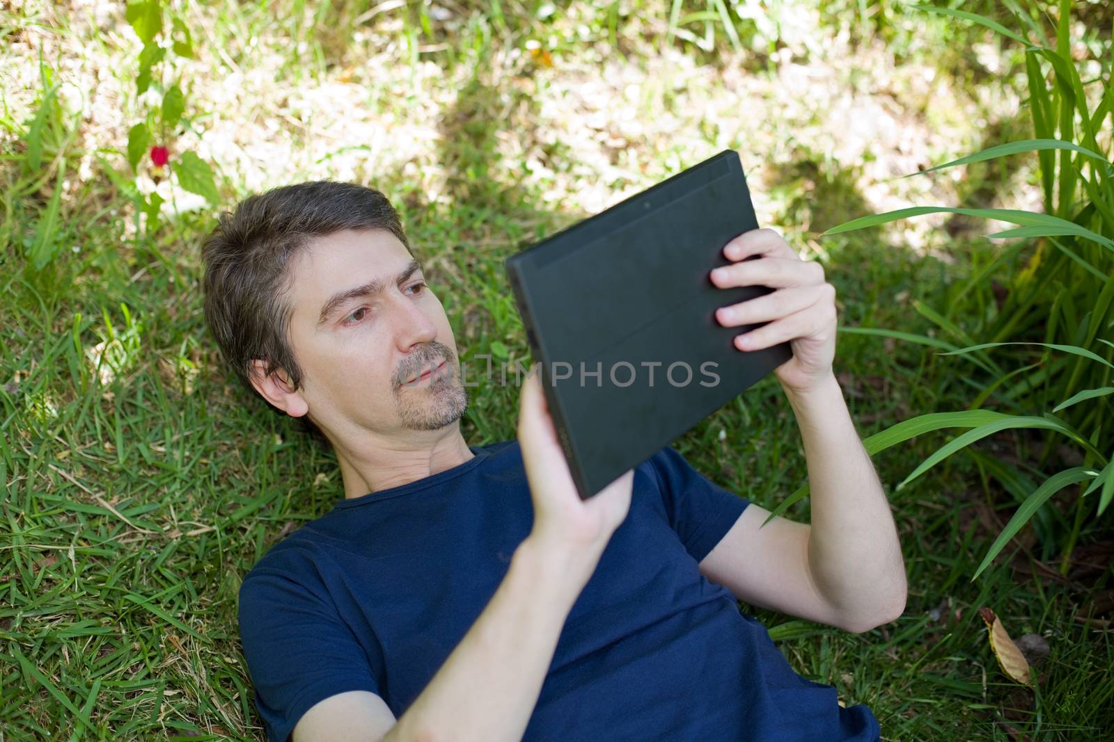 casual man working with a tablet pc, outdoor