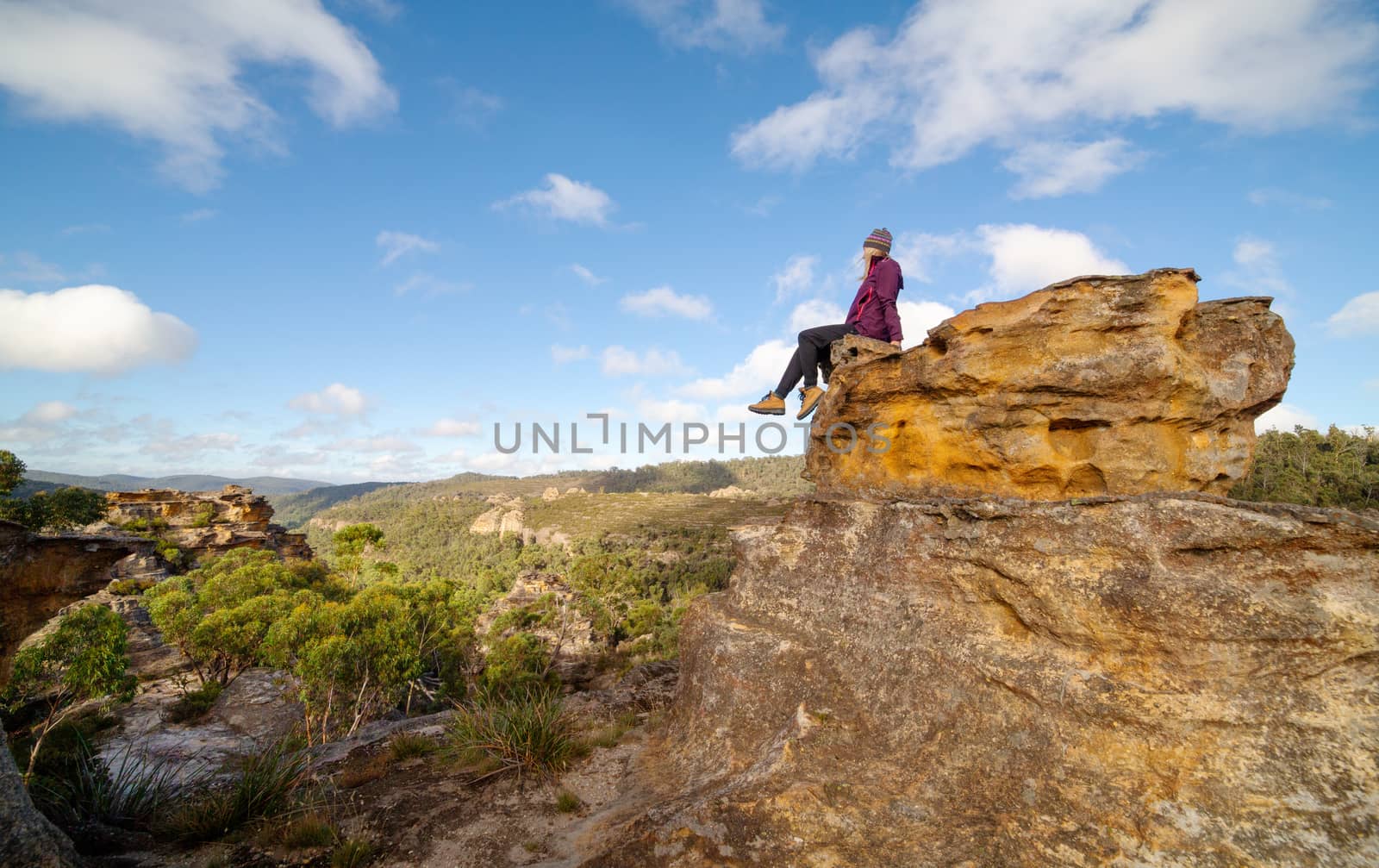 A bushwalker sits high atop a landscape of pagodas, valleys, gullies and canyons by lovleah
