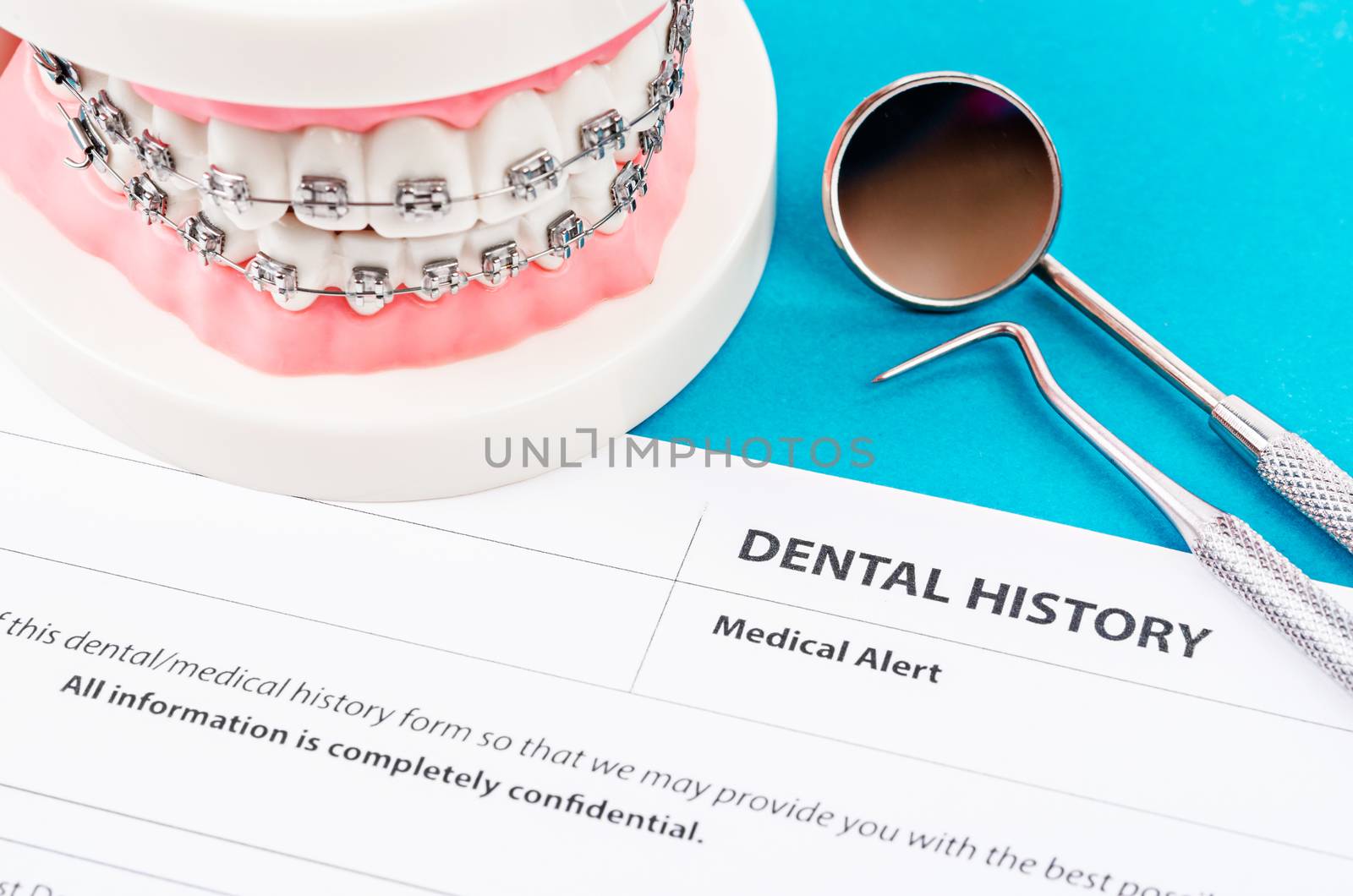 Dental history form with model tooth and dental instruments. Dental health and teeth care concept.