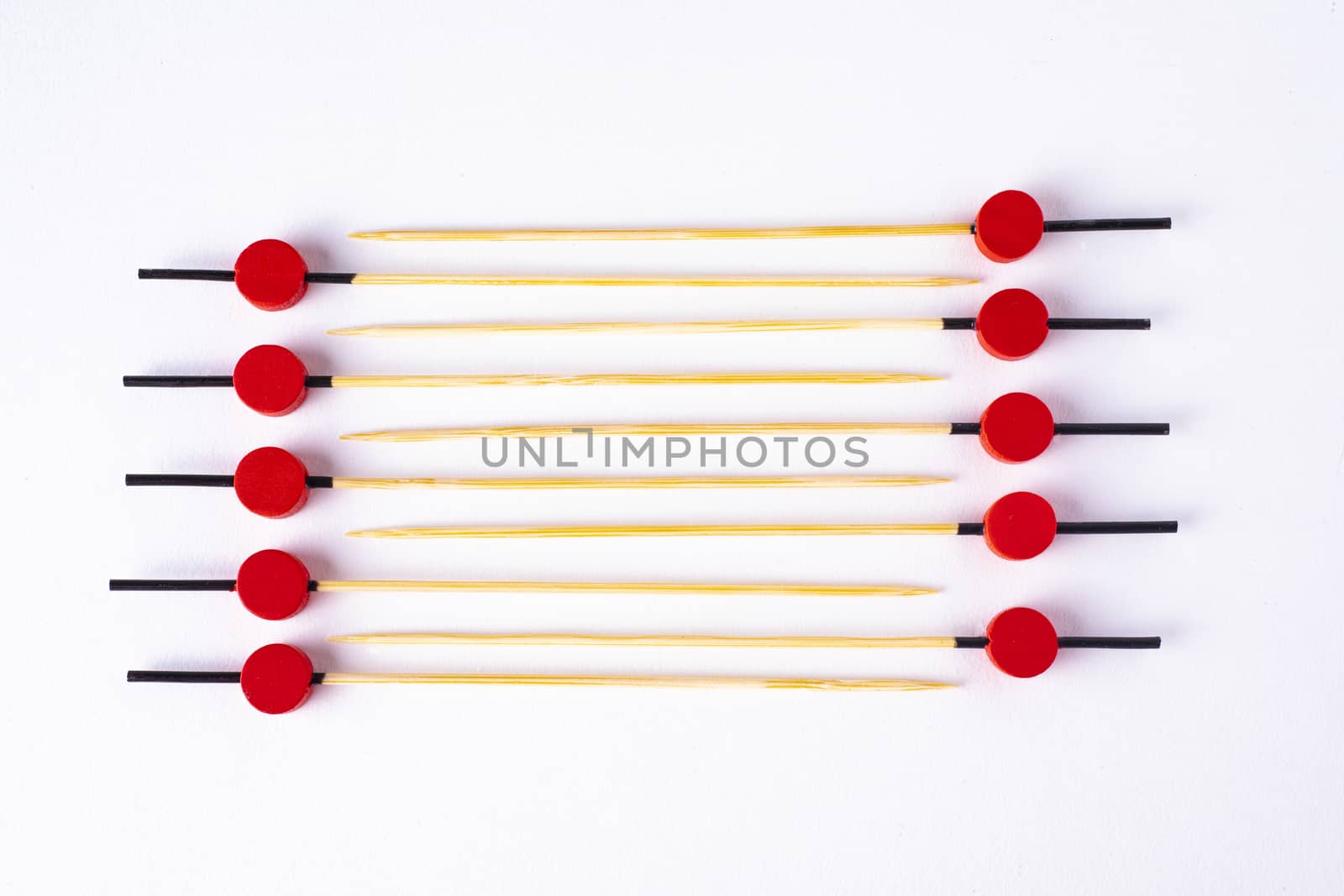 Ladder of colorful food skewers on white background.