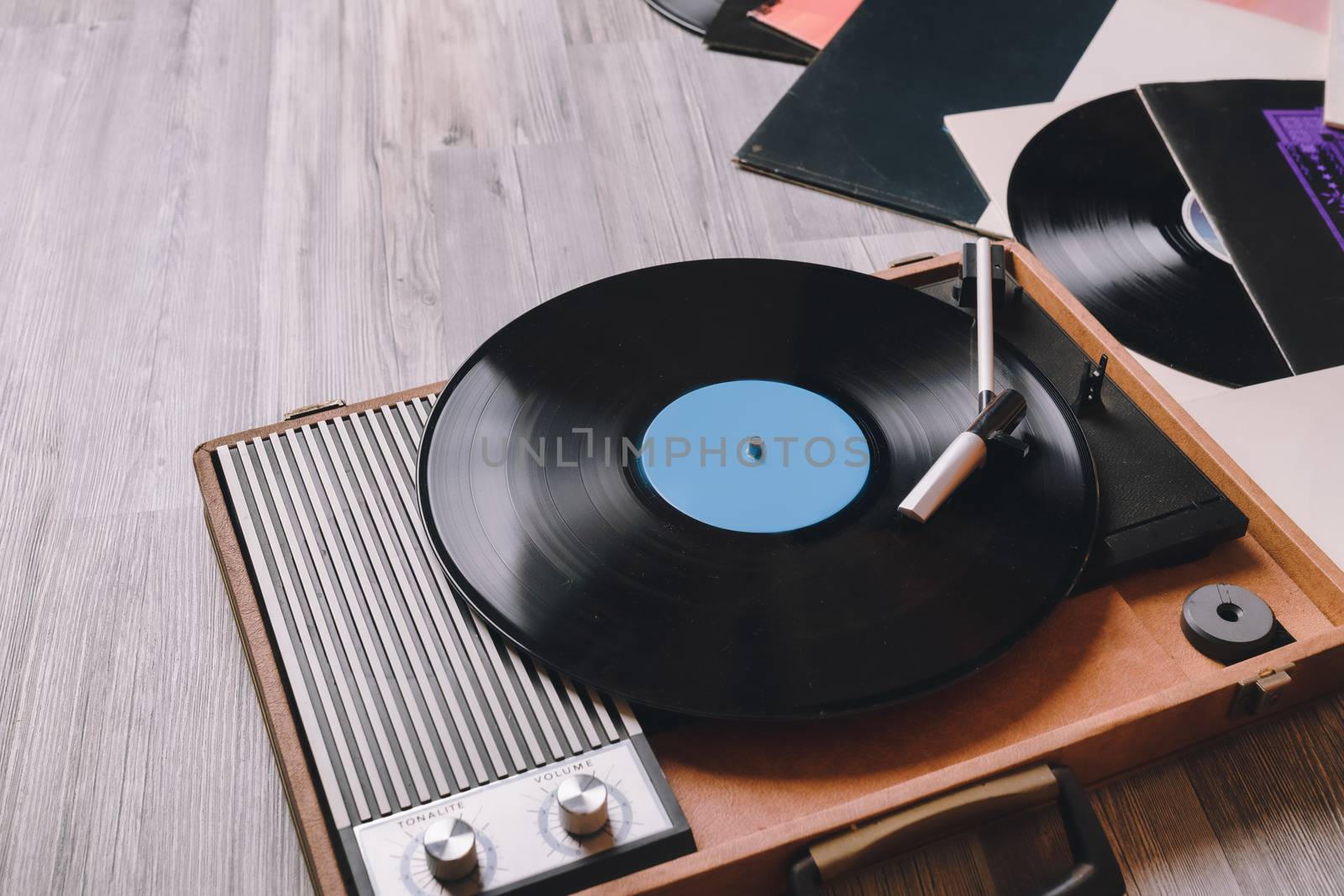 Vintage Gramophone with a vinyl record on gray wooden table, top view and copy space.