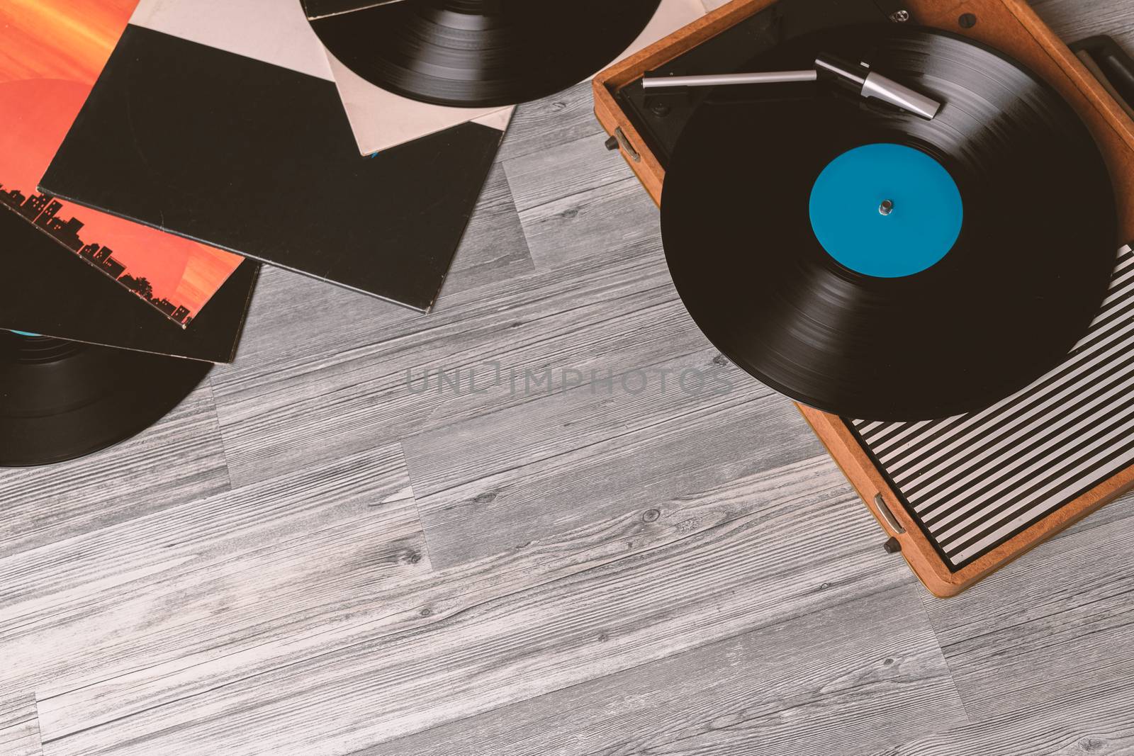 Vintage Gramophone with a vinyl record on gray wooden table, top view and copy space.