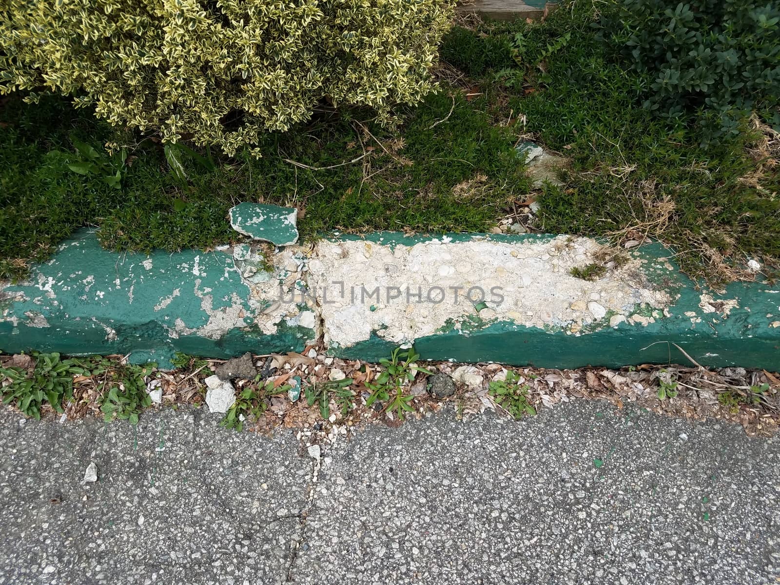 broken or worn green cement curb with asphalt by stockphotofan1