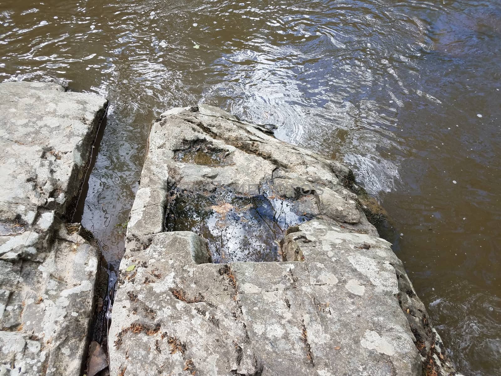 grey stone or boulder in river or stream water by stockphotofan1