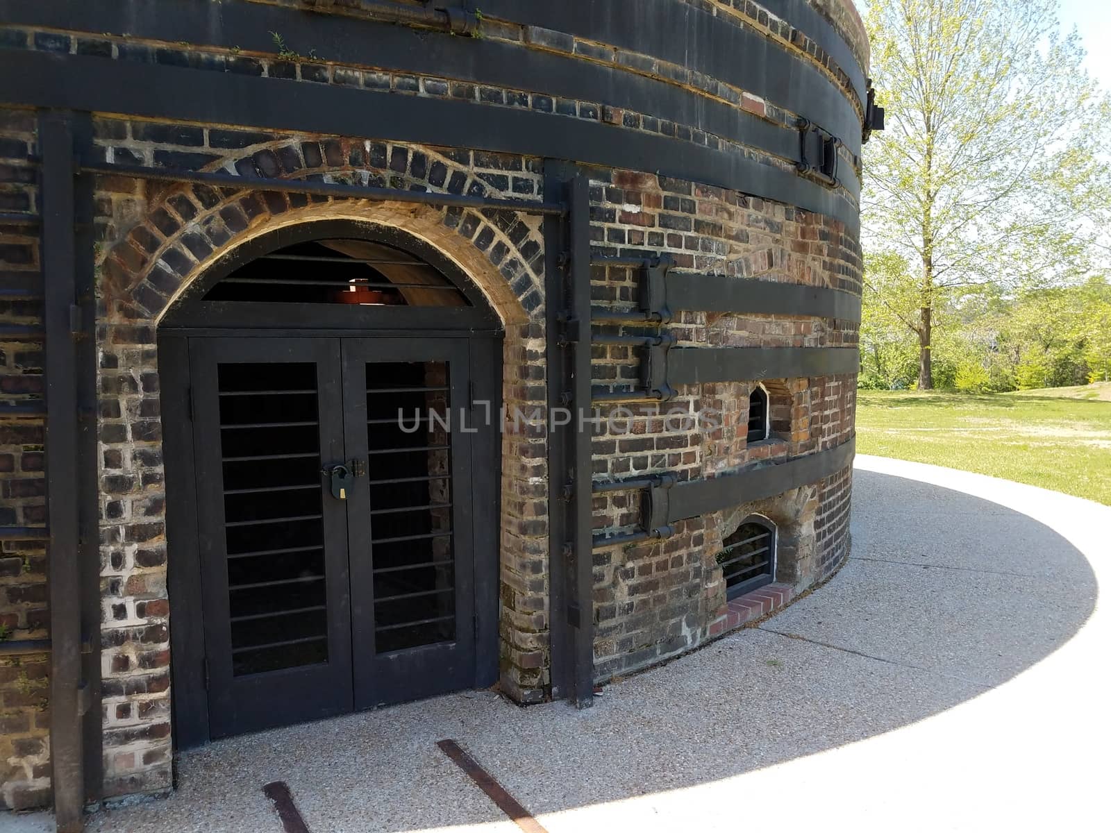 curved brick or masonry building with metal reinforcement and metal lock securing a closed door