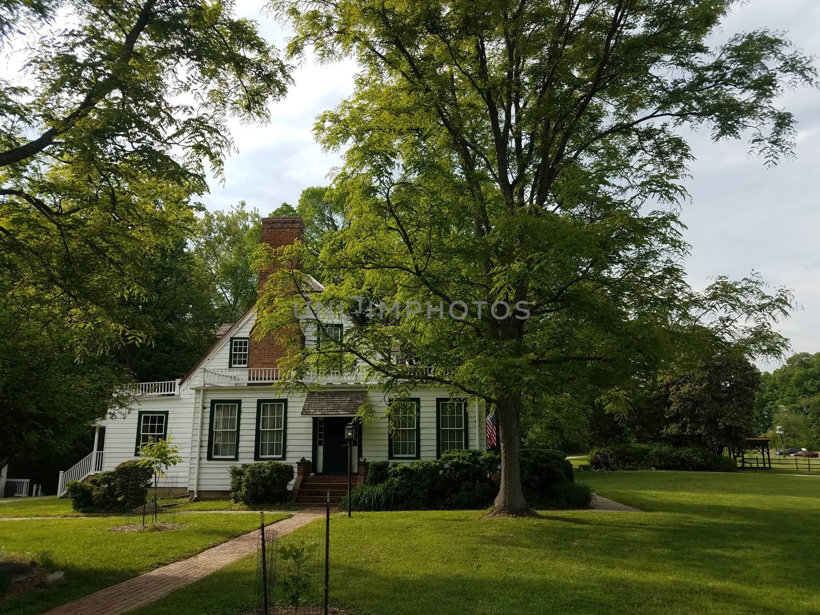 white house with windows and red chimney and green grass and trees