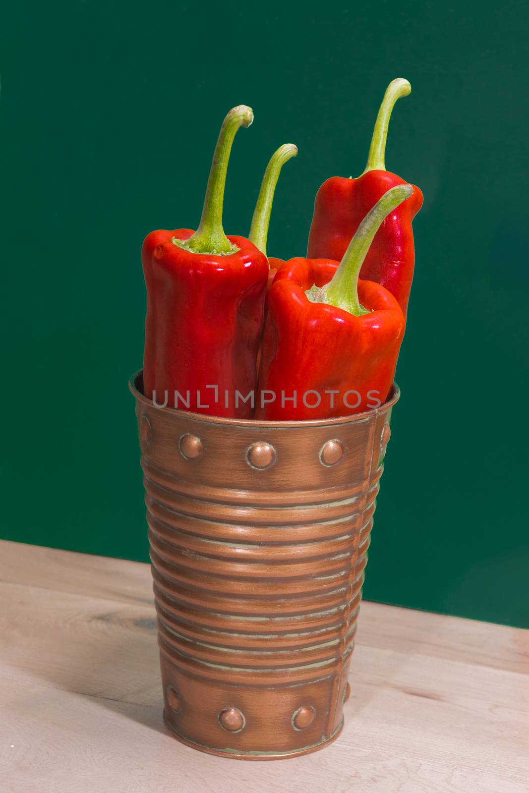 Marconi sweet long pepper in a bucket against a green background