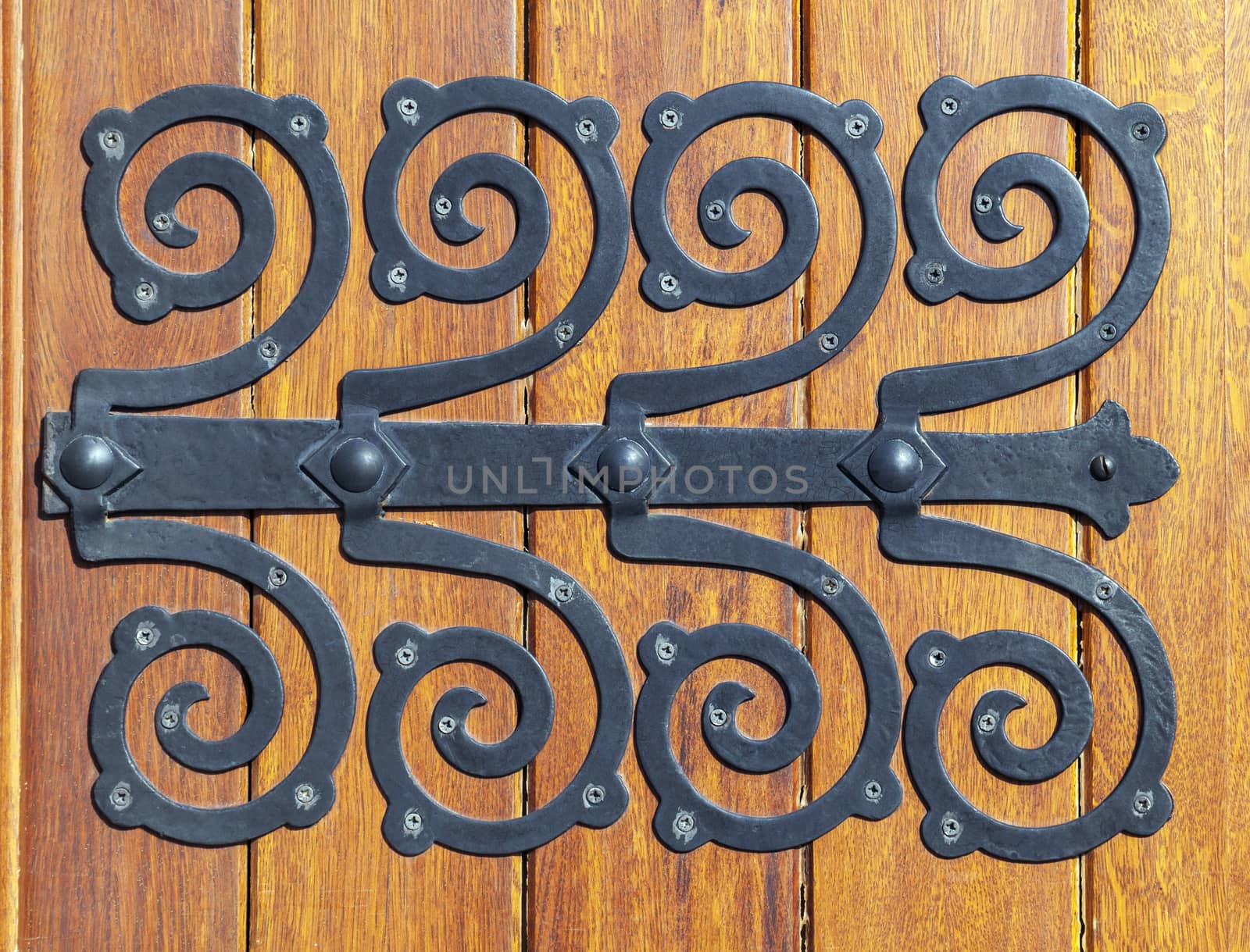 Decorative metal hinge on an old wooden door