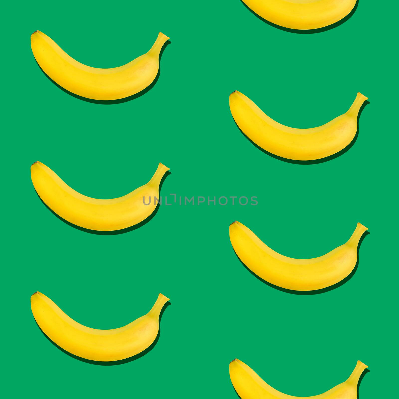 Seamless pattern of fresh ripe yellow bananas on green background