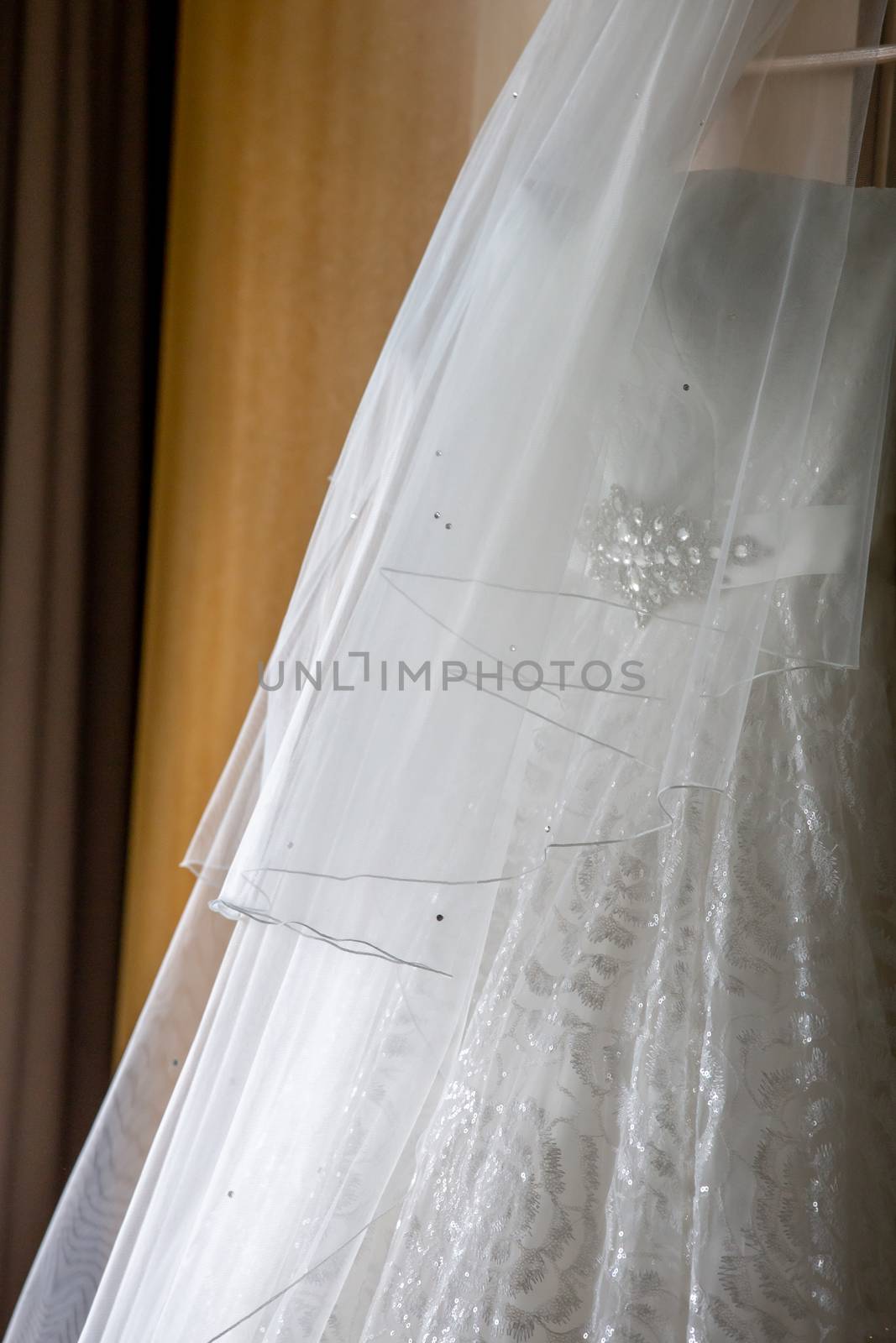 Bridal dress hanging at wooden closet by fotorobs