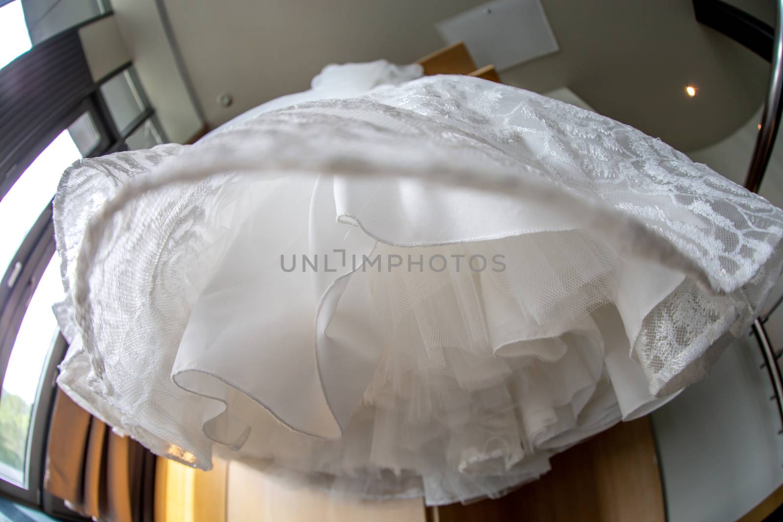 Bridal dress hanging at wooden closet by fotorobs