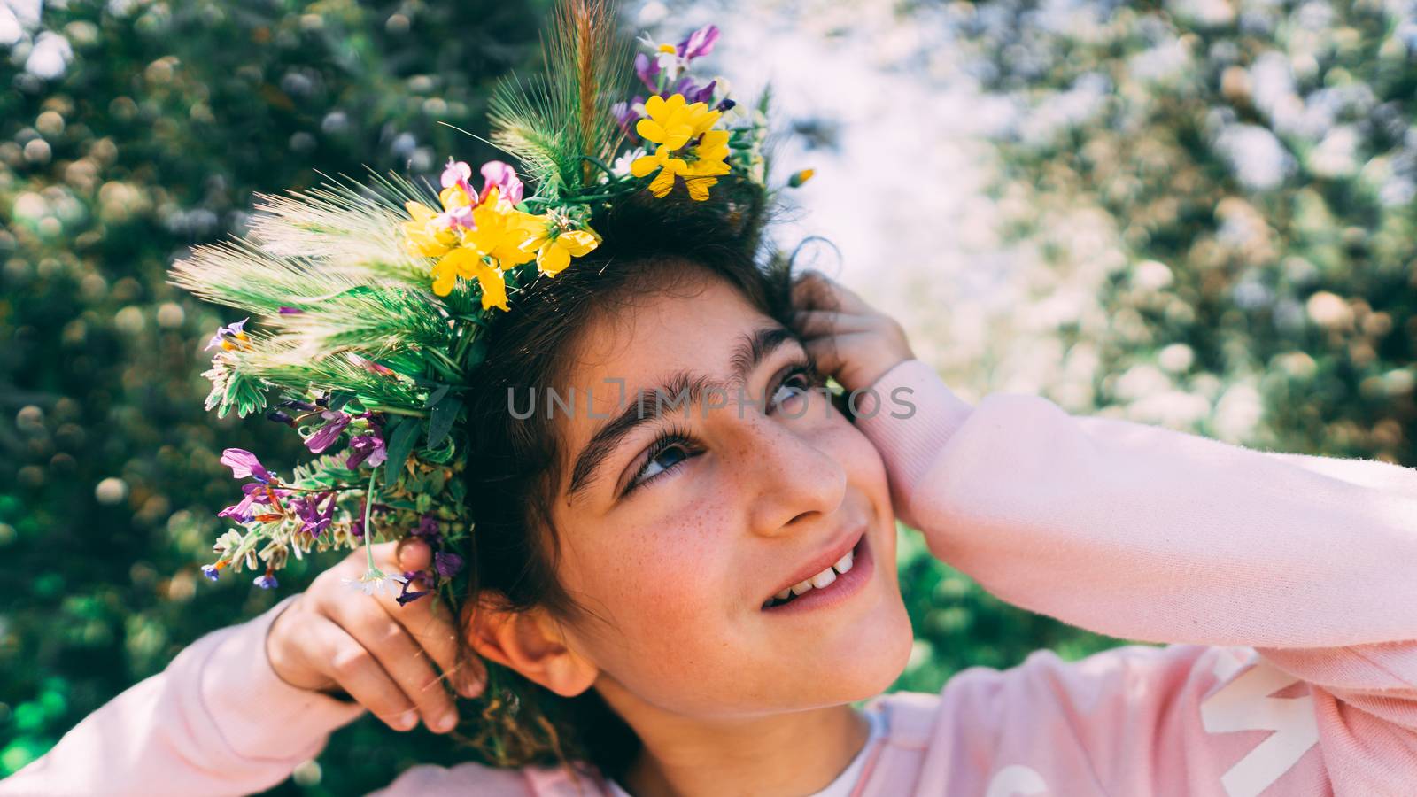 Little caucasian girl with crown from flowers.