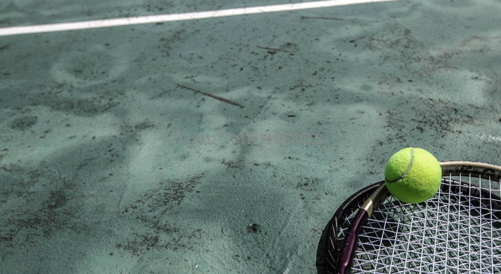 Tennis ball and racket in outdoor tropical court