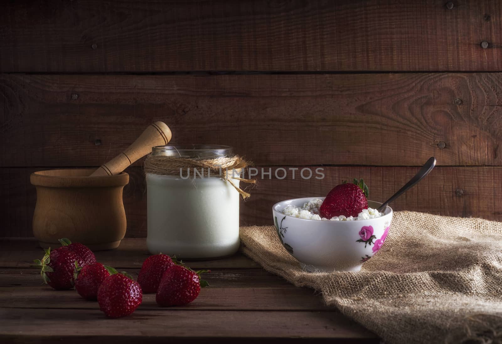 Tvorog, farmers cheese, curd cheese or cottage cheese in bowl with fresh strawberry. by dmitry_derenyuk
