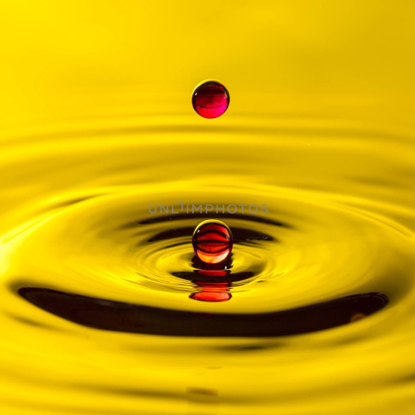 Close up of red water or blood droplet or splash-Image, yellow backgroung by petrsvoboda91