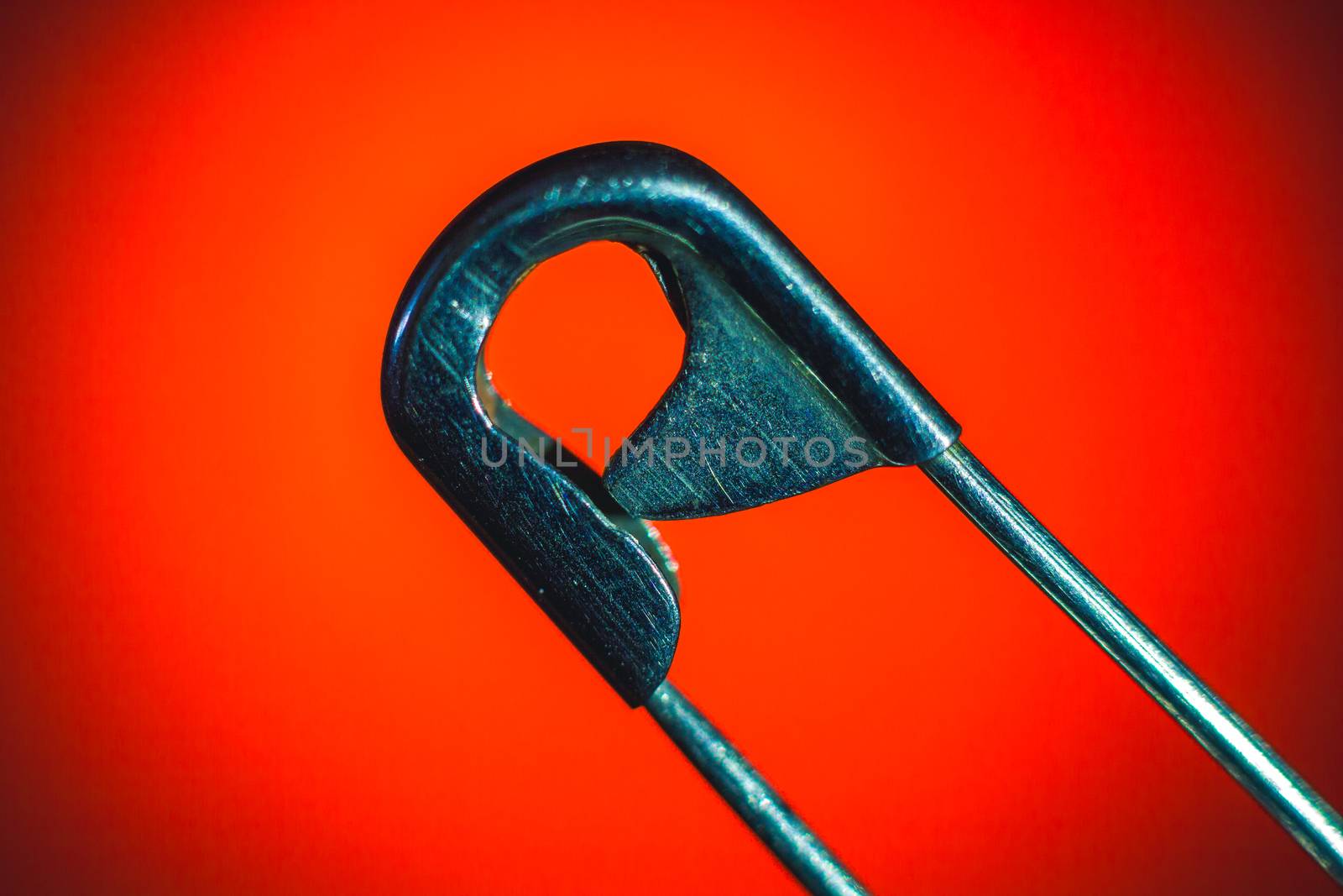 Maetal Safety Pin macro photo on red background