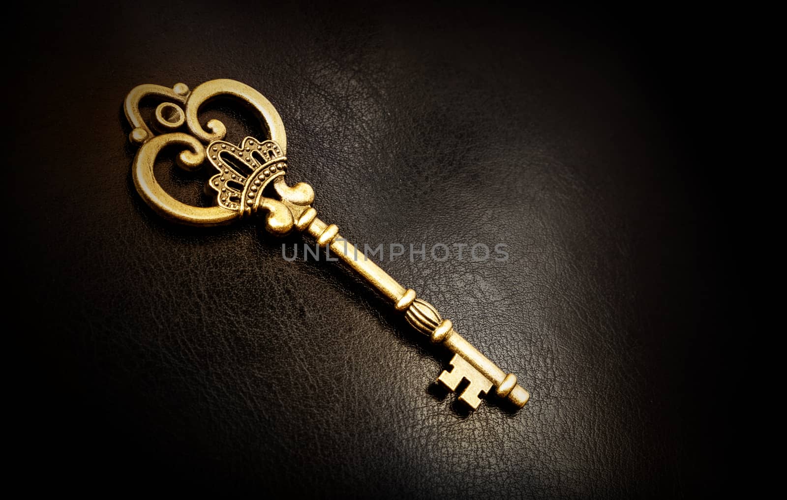 Old bronze key on a dark background, texture of the skin