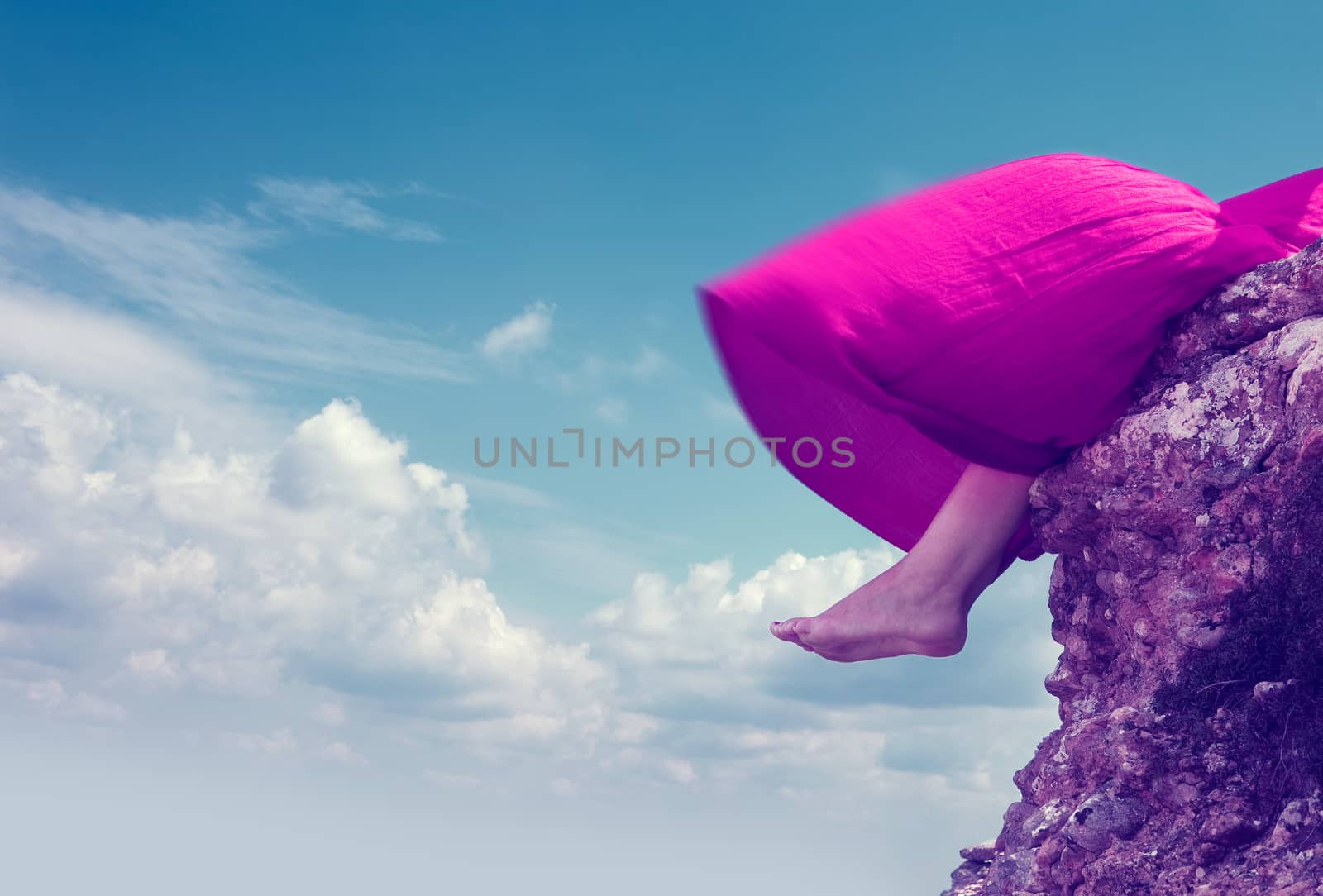 Girl sitting on the edge of a mountain