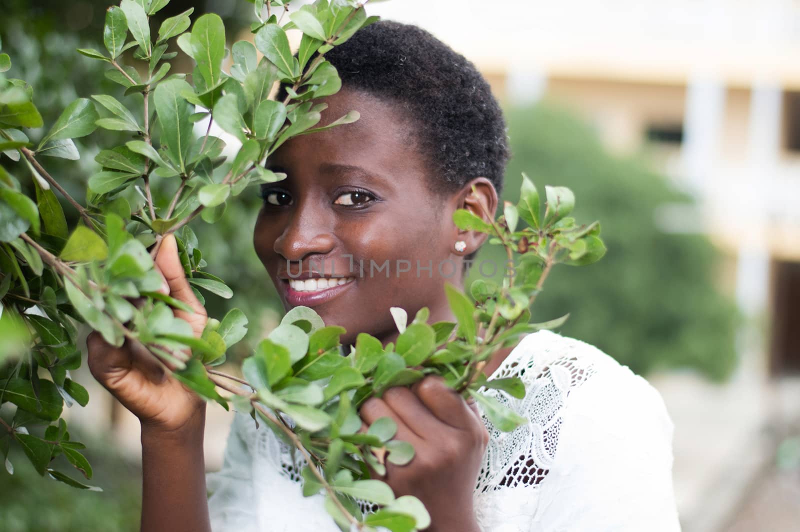 young woman hidden behind the foliage to protect against the sun.