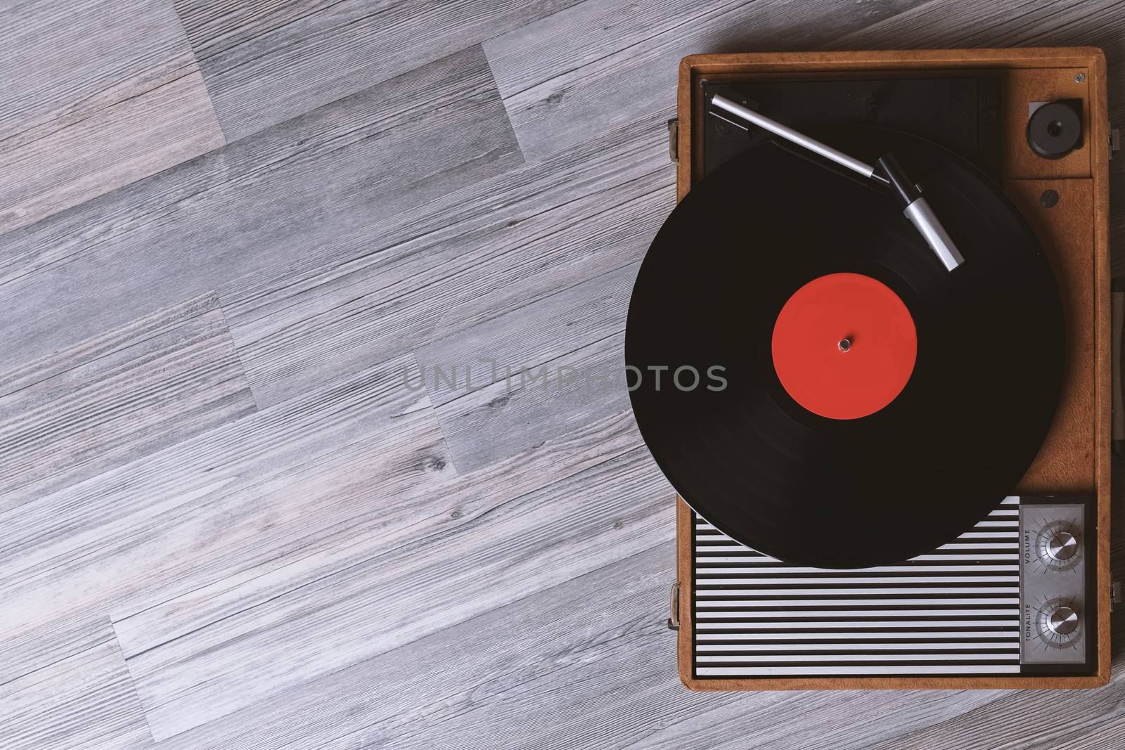 Turntable vinyl record player on the background of their gray wooden boards. Needle on a vinyl record. Black vinyl record,Sound technology for DJ to mix & play music.