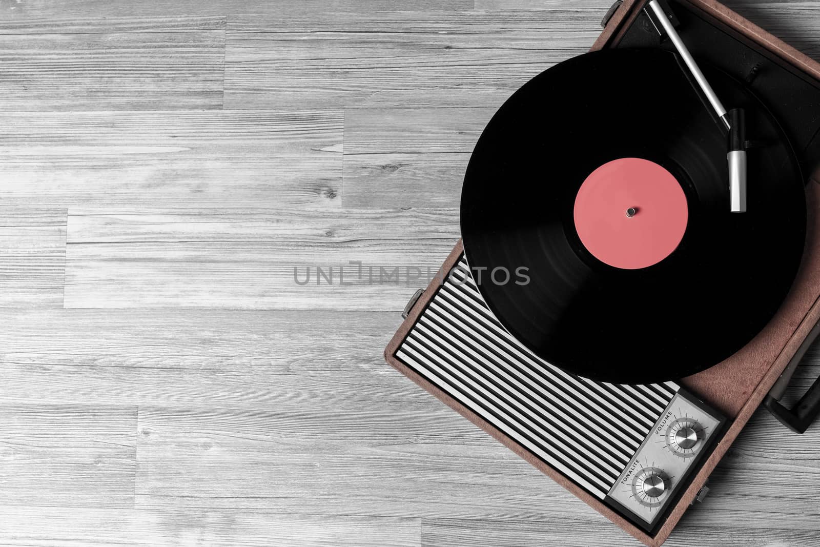 Vintage turntable with a vinyl record on gray wooden table, top view and copy space.desaturate photo.