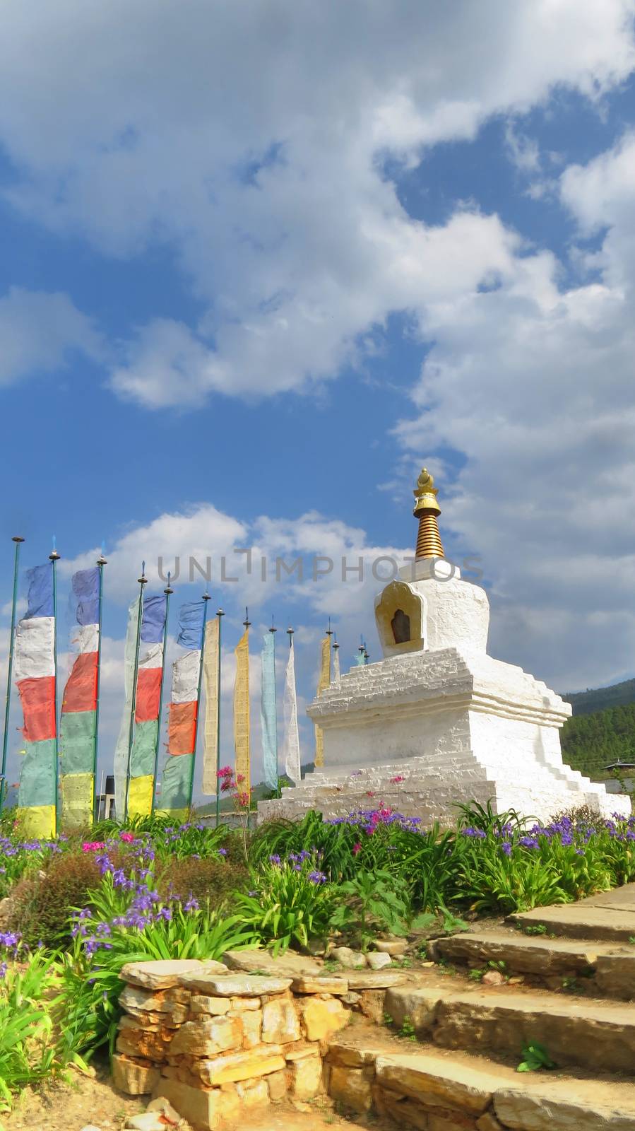 A beautiful structure of a Stupa surrounded by colorful flowers, in Bhutan                               