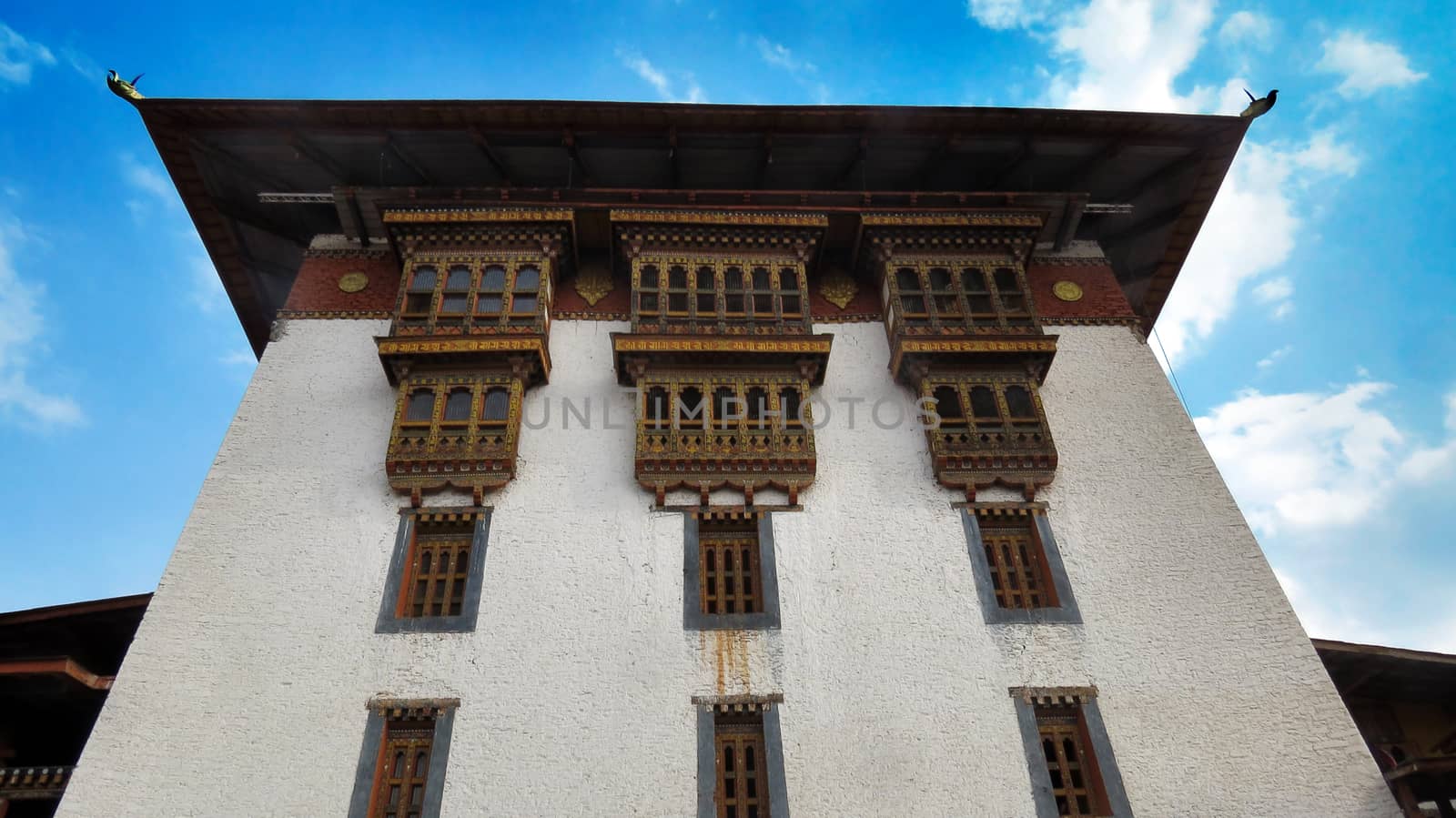 The beautiful architectural design of the dzong in Punakha, Bhutan, against blue skies.