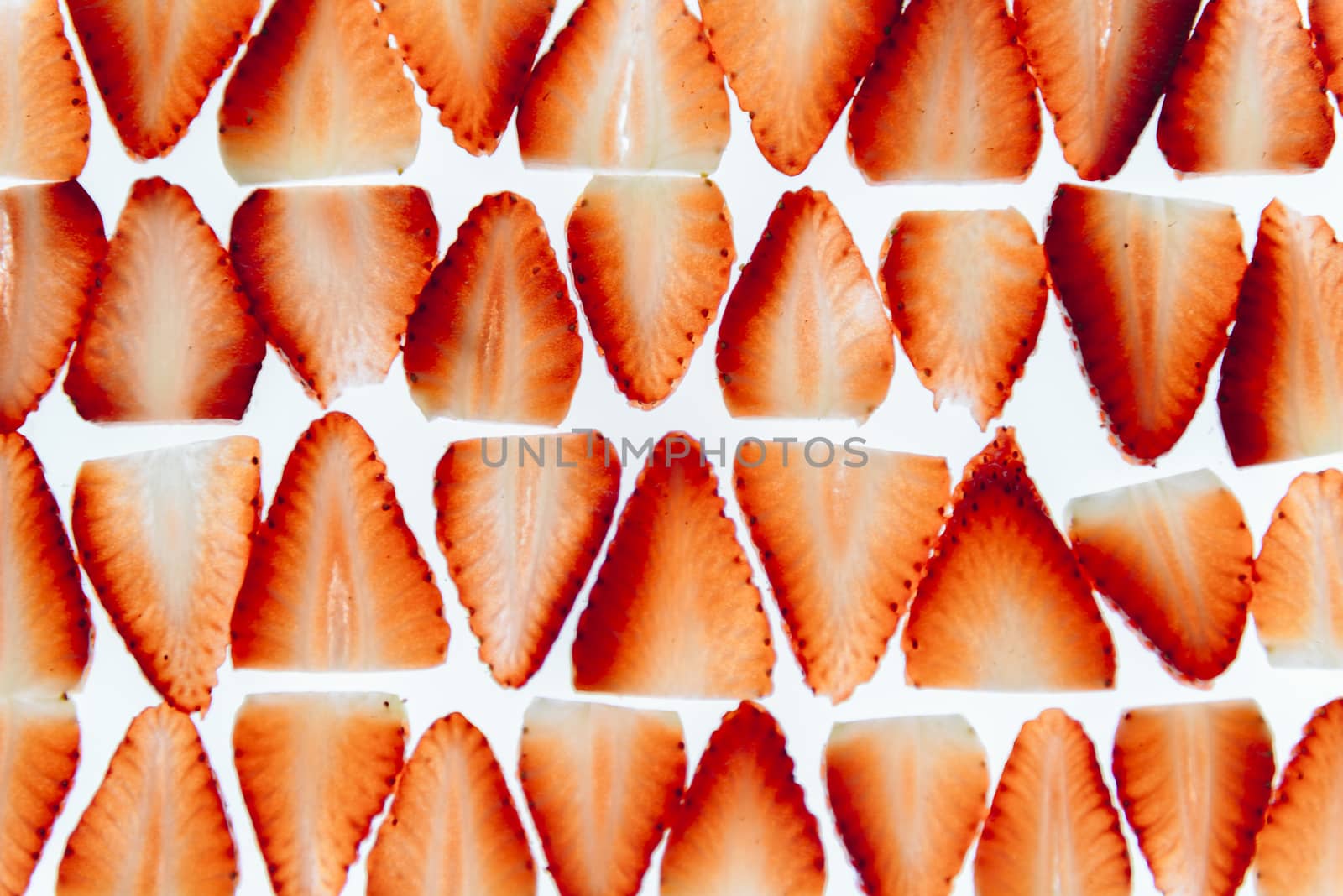 sliced fresh strawberries isolated on white background, neatly arranged slices of red strawberry on a white background, healthy sweet food, vitamins and fruity concept, top view