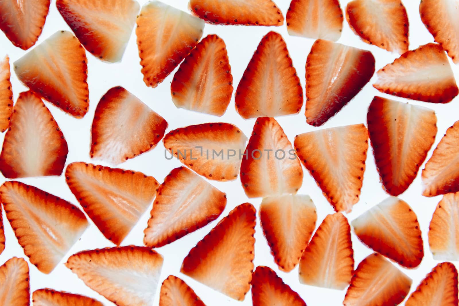 sliced fresh strawberries isolated on white background, messy arranged slices of red strawberry on a white background, healthy sweet food, vitamins and fruity concept, top view