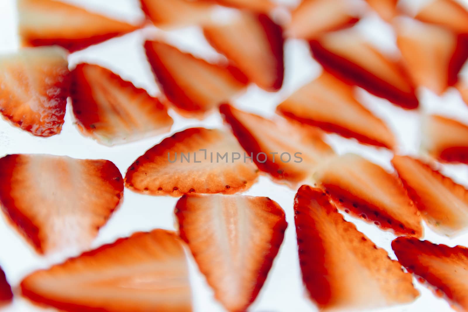 sliced fresh strawberries isolated on white background, messy arranged slices of red strawberry on white background, healthy sweet food, vitamins and fruity concept, top view