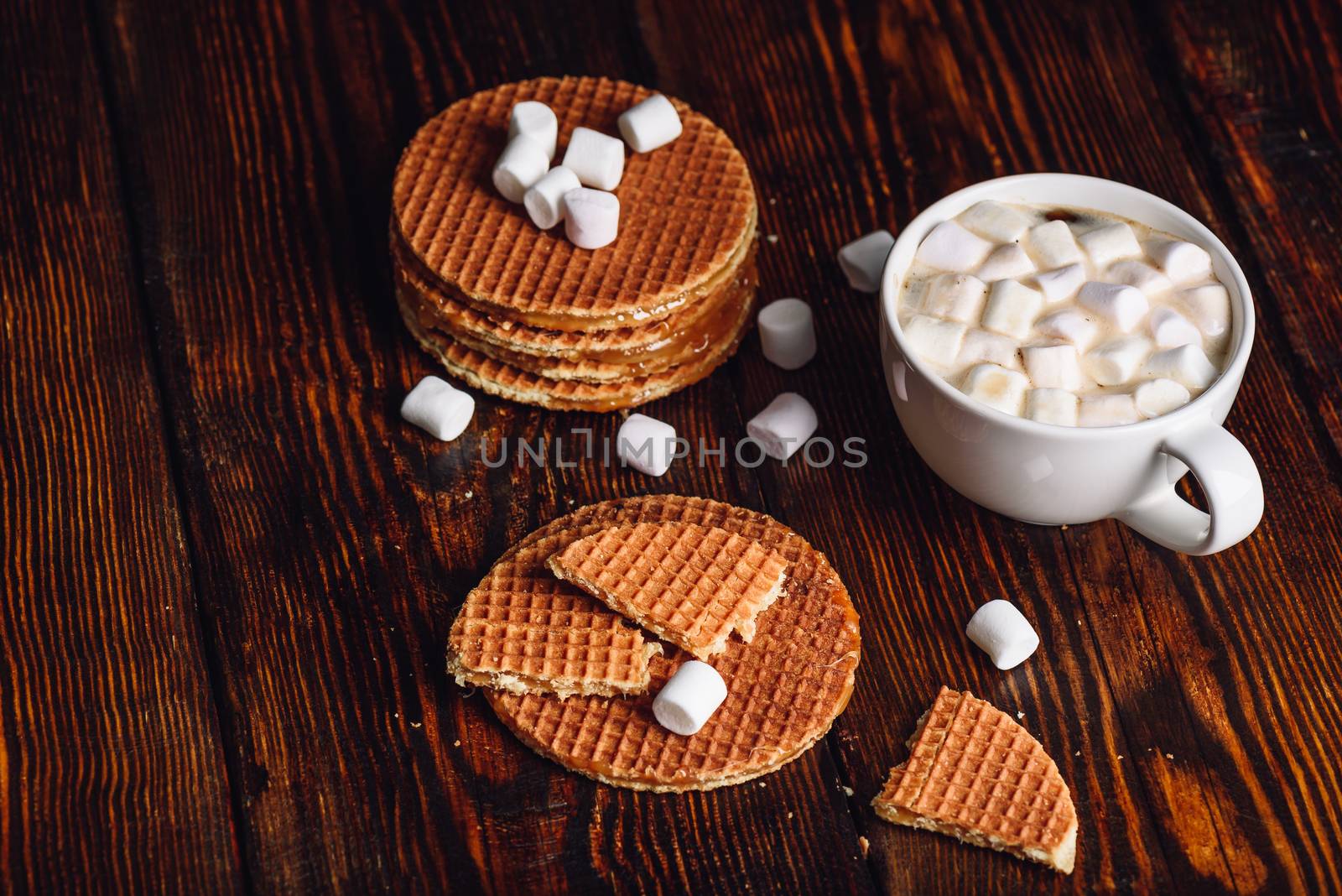 Stroopwafel with Broken One with White Cup of Cocoa with Marshmallow and Waffle Stack. Copy Space on the Left.