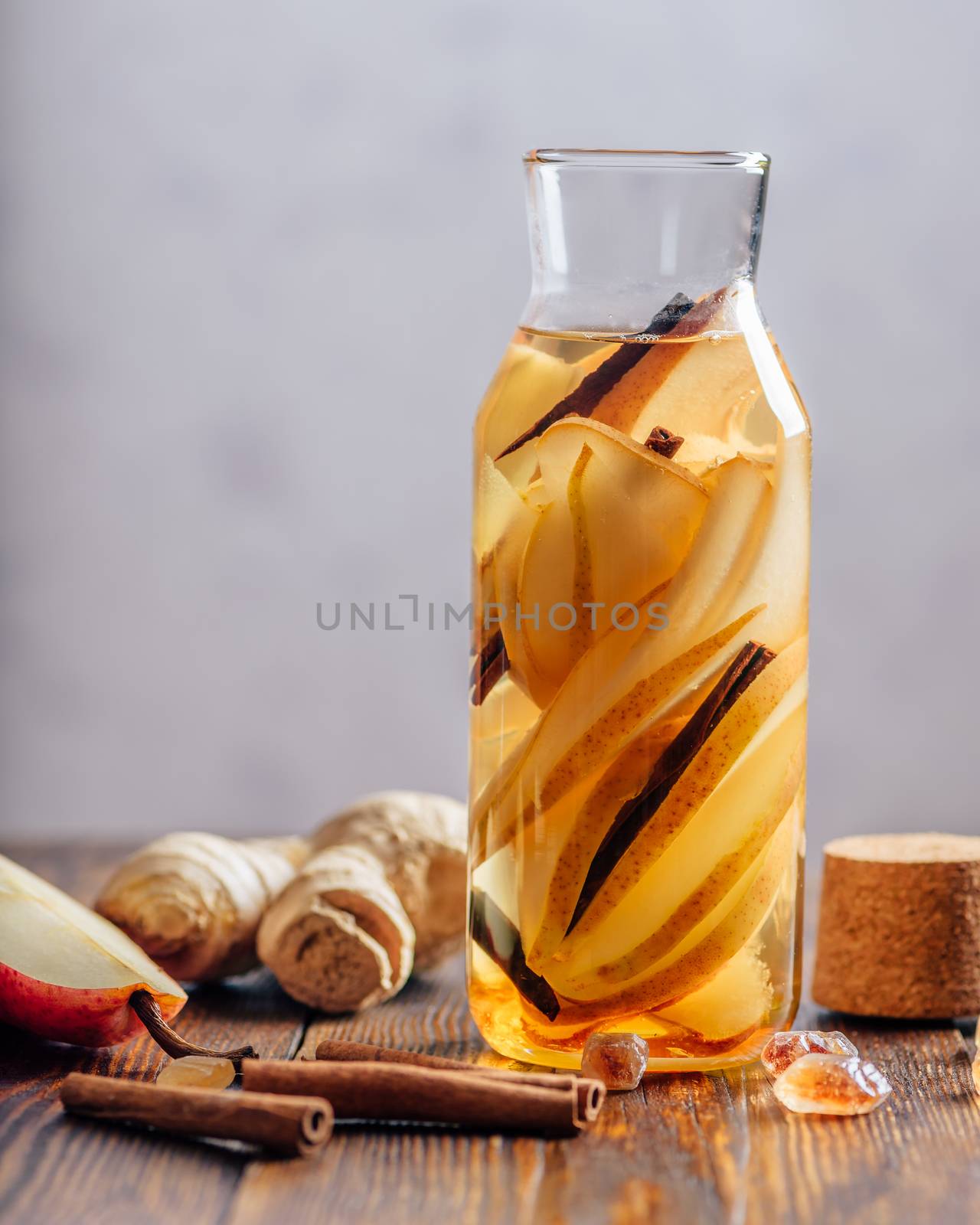 Water infused with Pear, Ginger Root and Cinnamon Stick. Some Ingredients on Table. Vertical Orientation and Copy Space.