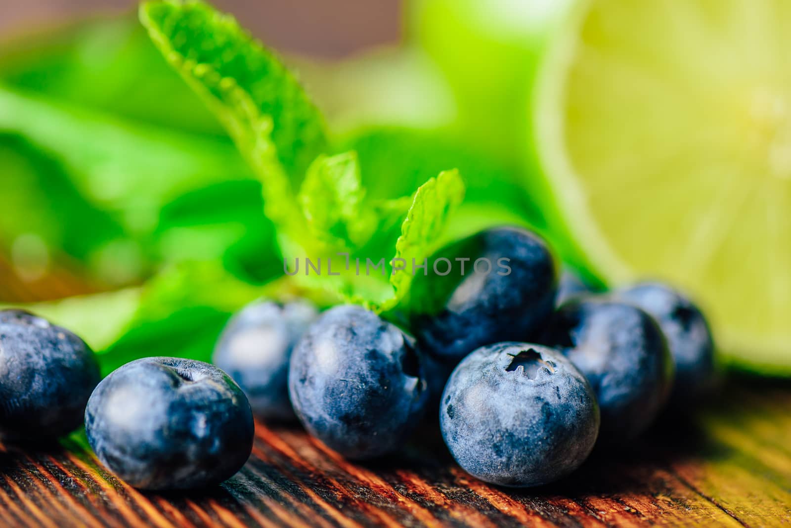 Fresh Blueberries and Half of Lime and Mint Leaves on Backdrop. Ingredients for Prepare Cleansing Water.