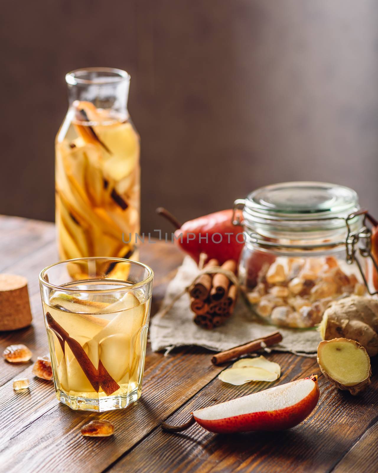 Detox Water Infused with Sliced Pear, Cinnamon Stick, Ginger Root and Some Sugar. Ingredients on Wooden Table. Vertical Orientation.