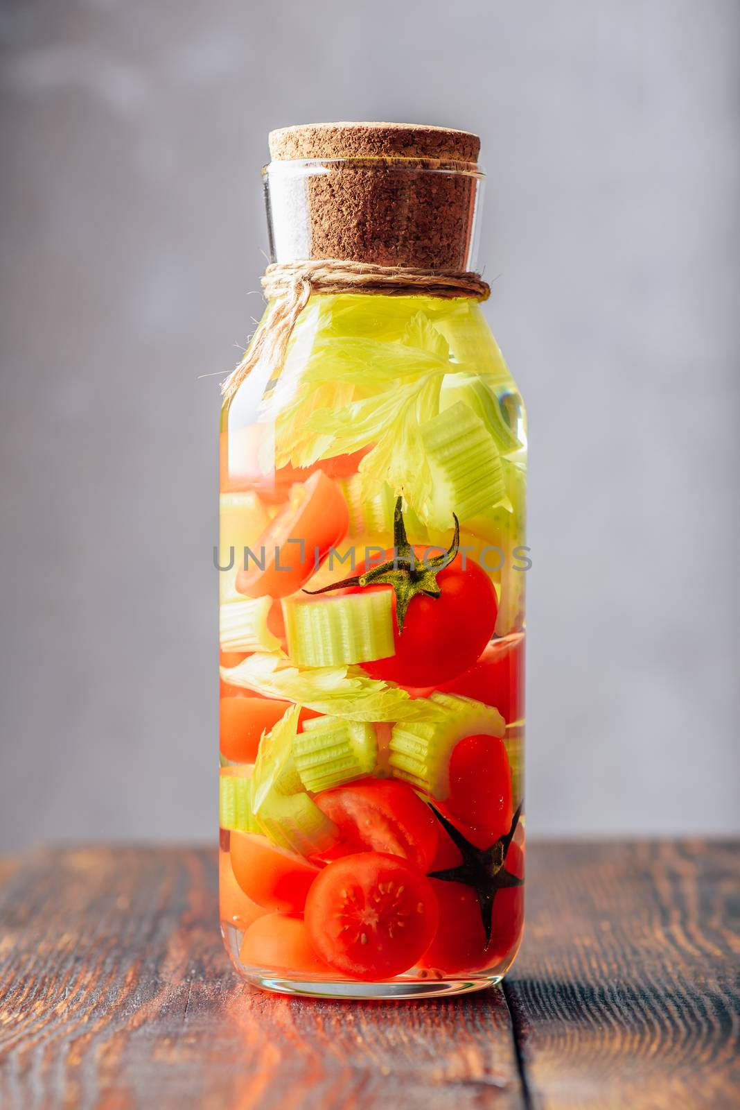 Bottle of Detox Water with Cherry Tomato and Celery Stems. Vertical Orientation.