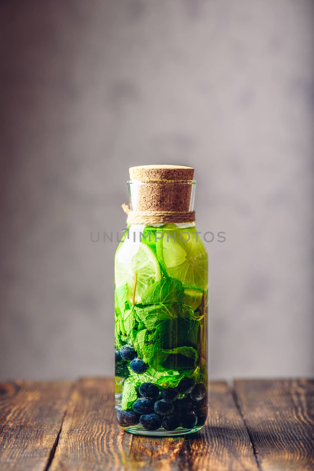 Bottle of Cleansing Water with Lime, Mint and Blueberry. Copy Space and Vertical Orientation.