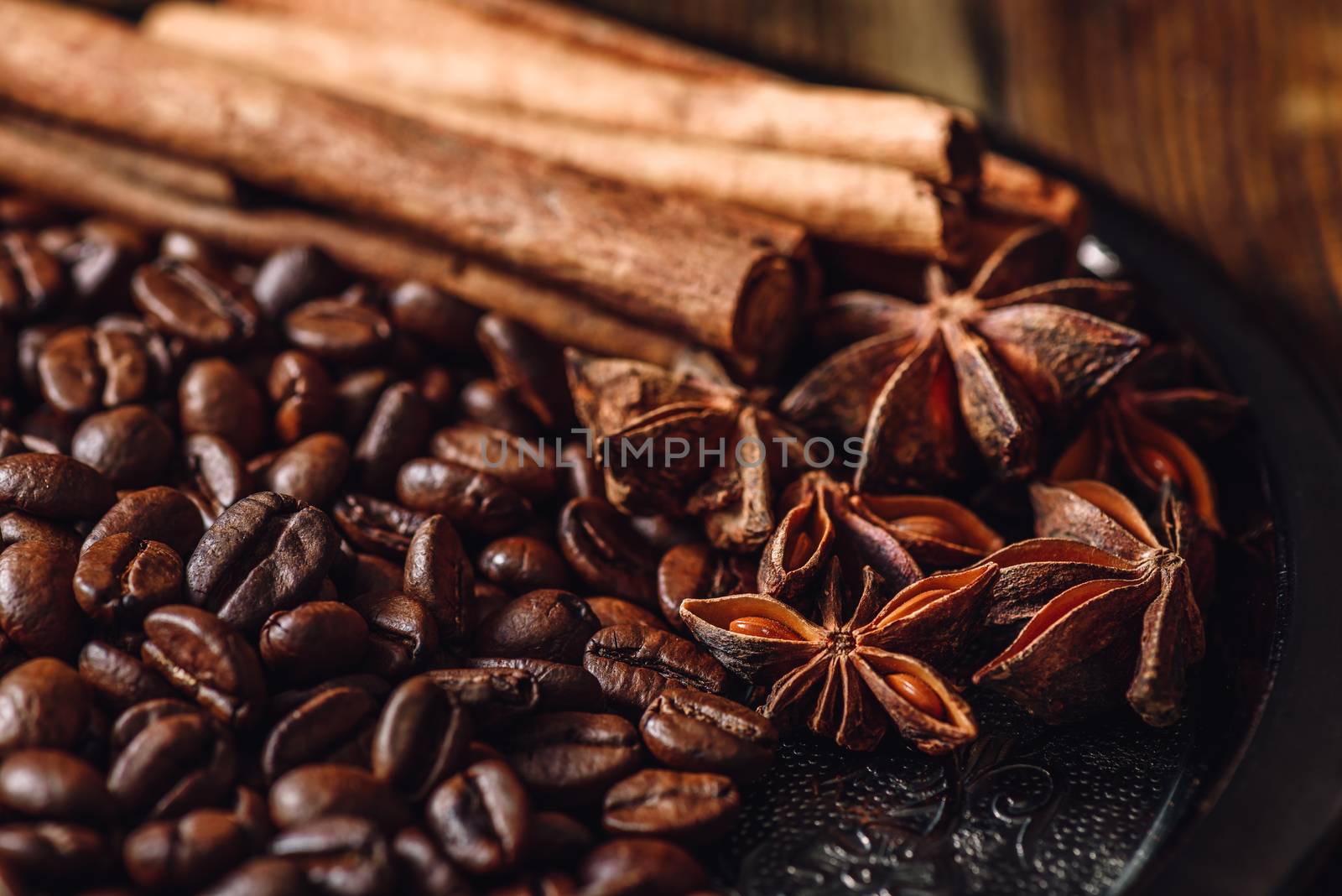 Coffee Beans with Cinnamon Sticks and Chinese Star Anise on Metal Plate.