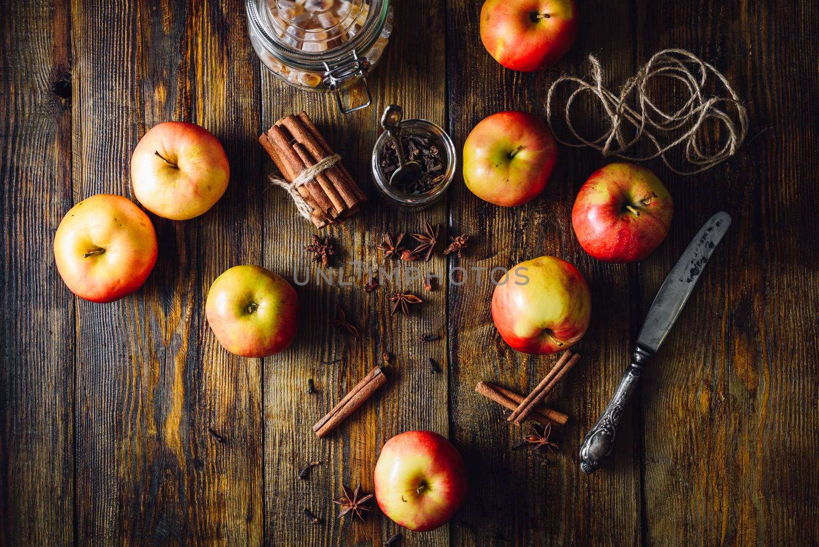 Red Apples with Scattered Clove, Cinnamon and Anise Star. Candy Sugar and Some CLove in a Jar. Ingredients for Prepare Christmas Drink