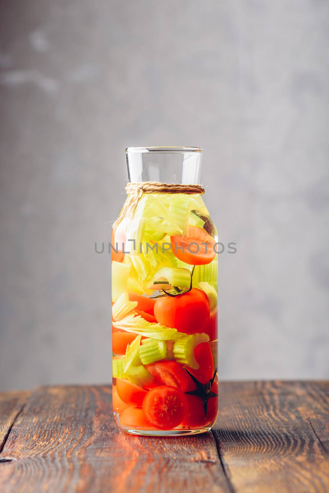 Water Flavored with Cherry Tomato and Celery Stems. Vertical Orientation.